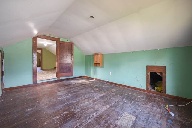 additional living space featuring vaulted ceiling and hardwood / wood-style flooring