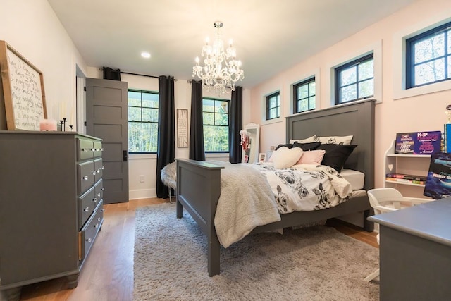 bedroom with a chandelier and light hardwood / wood-style flooring