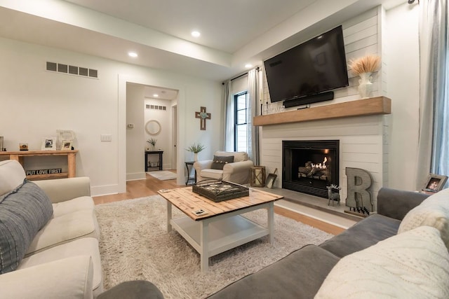 living room with a fireplace and light hardwood / wood-style flooring