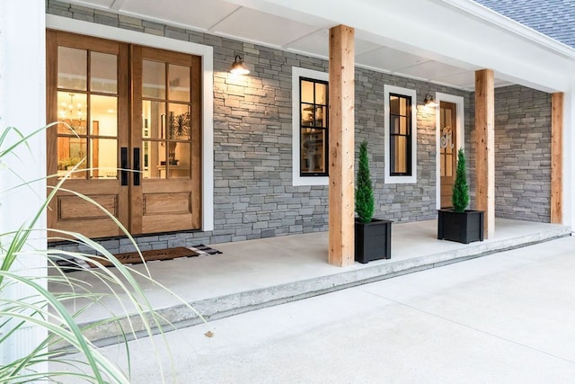 view of exterior entry with a porch and french doors