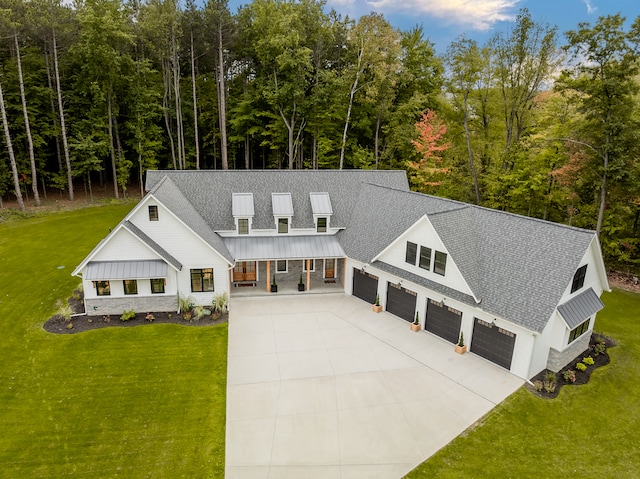 view of front facade featuring a front lawn, covered porch, and a garage