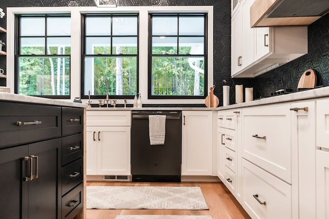 kitchen with white cabinetry, stainless steel dishwasher, light hardwood / wood-style floors, and custom exhaust hood