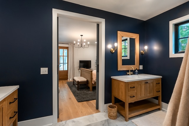 bathroom with a chandelier, hardwood / wood-style floors, vanity, and plenty of natural light