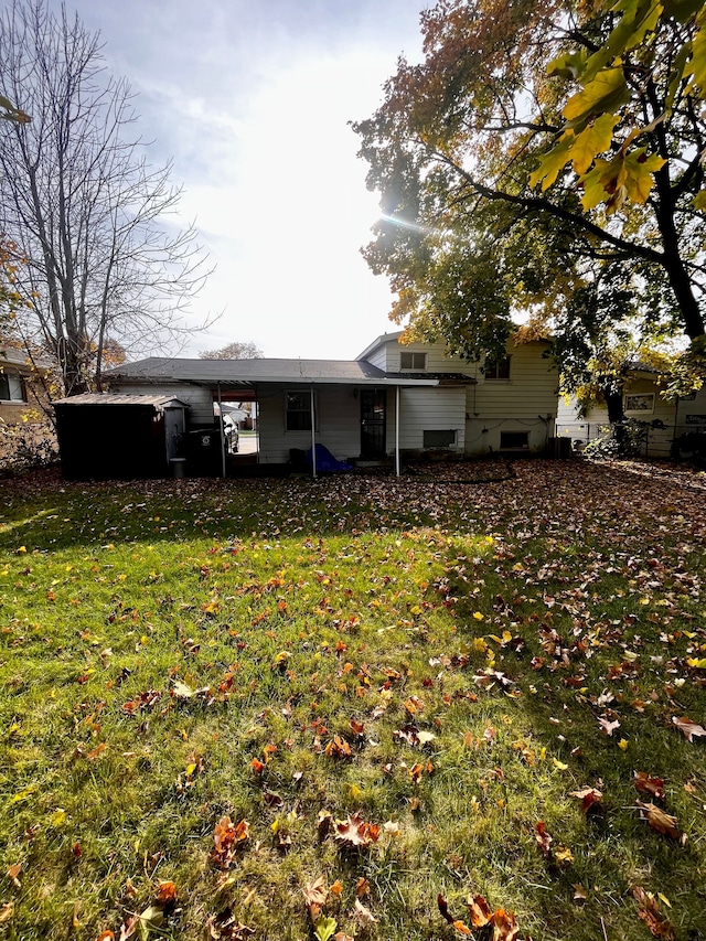 rear view of property featuring a lawn