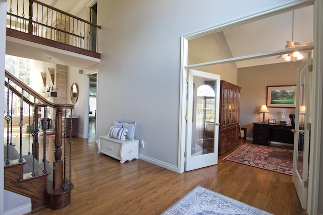 foyer with french doors, hardwood / wood-style floors, a towering ceiling, and ceiling fan