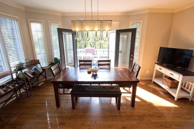 dining room with dark hardwood / wood-style flooring, ornamental molding, and an inviting chandelier