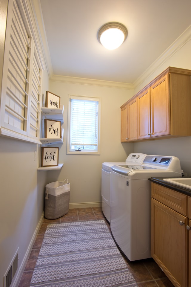 clothes washing area with cabinets, ornamental molding, and washing machine and clothes dryer