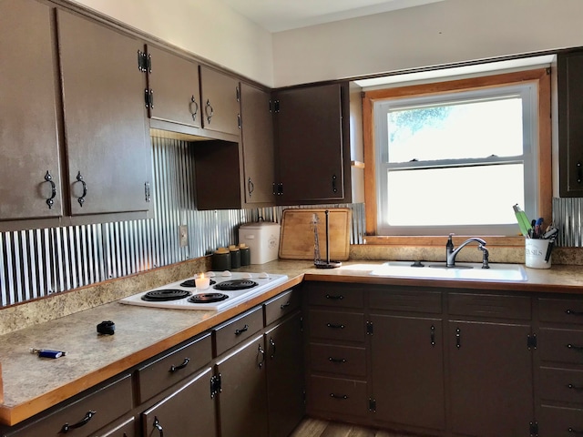 kitchen featuring light wood-type flooring, sink, and white electric stovetop