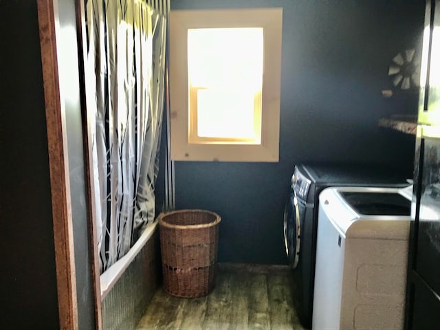 laundry room with dark hardwood / wood-style flooring and washing machine and clothes dryer