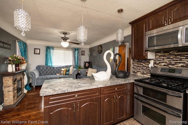 kitchen featuring decorative light fixtures, ceiling fan, dark brown cabinetry, and stainless steel appliances