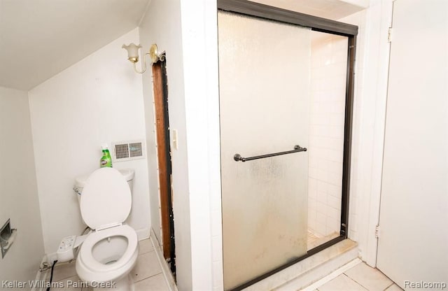 bathroom featuring toilet, tile patterned flooring, vaulted ceiling, and walk in shower