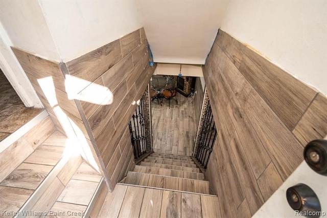 staircase featuring hardwood / wood-style floors and tile walls