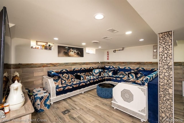 miscellaneous room with wood-type flooring and tile walls