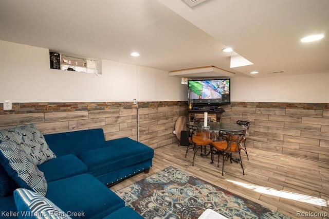 living room featuring hardwood / wood-style flooring and tile walls