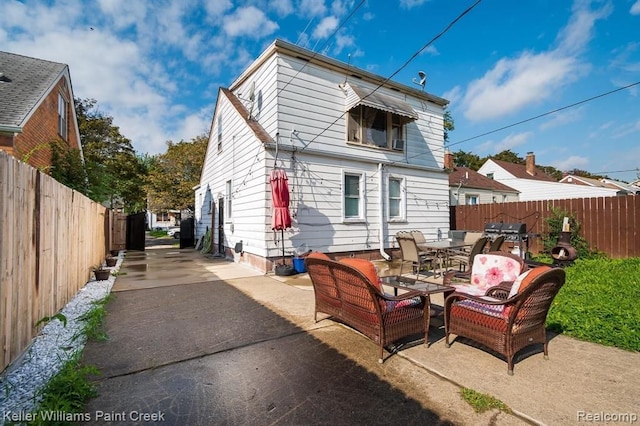 rear view of house with an outdoor living space and a patio area