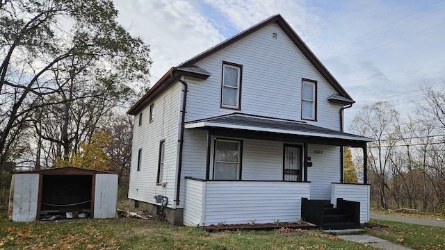 view of front of house with a porch and a storage shed