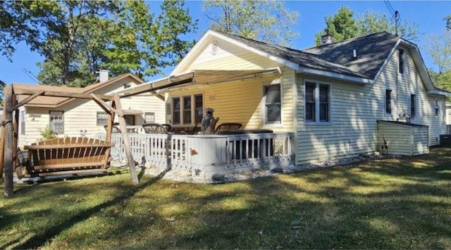 back of property featuring a deck and a yard