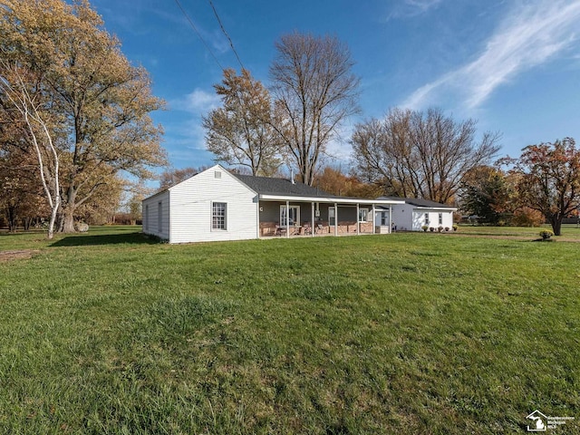 back of property featuring a sunroom and a lawn