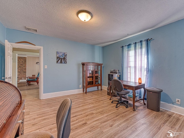 office space with a textured ceiling and light hardwood / wood-style floors