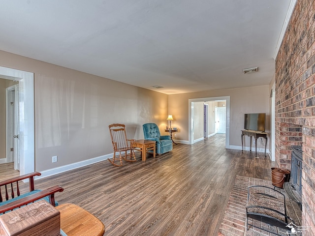 living area with a fireplace and dark wood-type flooring