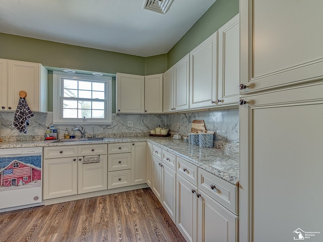 kitchen with white cabinets, wood-type flooring, white dishwasher, and sink