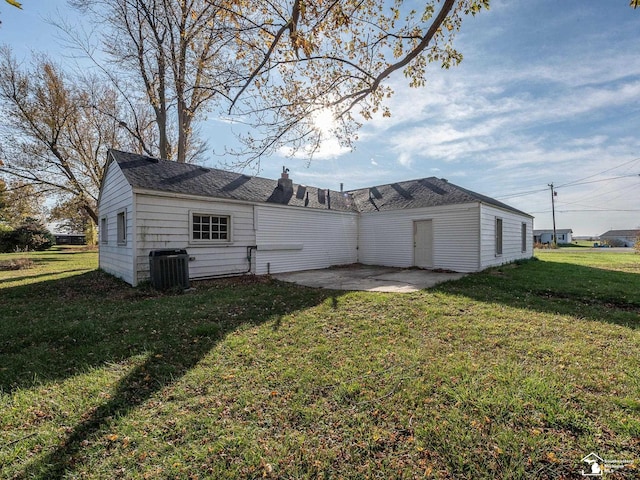 back of property featuring central AC unit, a patio area, and a yard