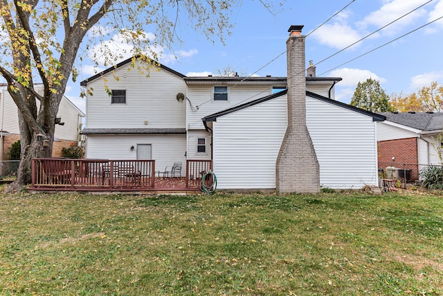 rear view of property featuring a yard and a deck