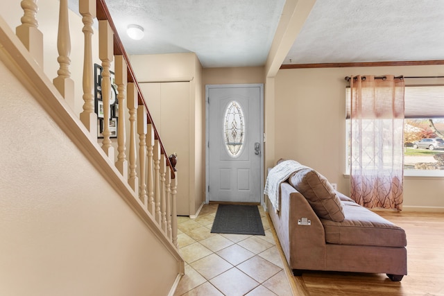 entrance foyer with light tile patterned floors and a textured ceiling