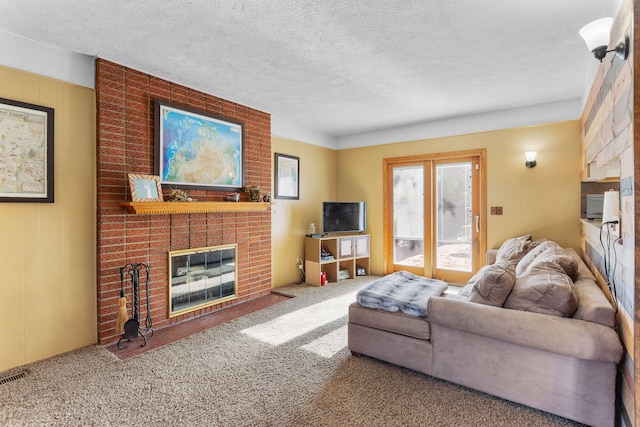 carpeted living room featuring a fireplace and a textured ceiling