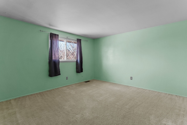 spare room featuring light carpet