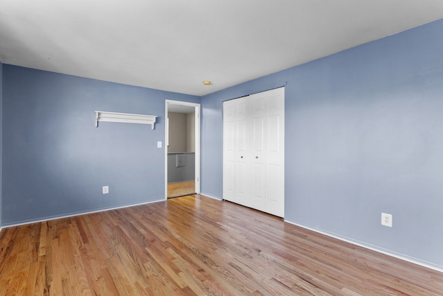 unfurnished bedroom with a closet and light hardwood / wood-style floors