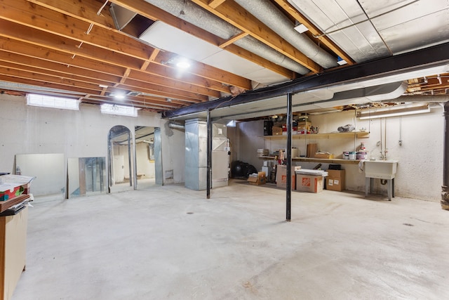 basement featuring heating unit and sink