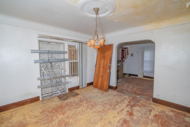 unfurnished dining area featuring a chandelier