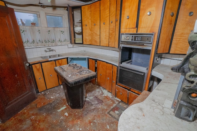 kitchen with backsplash, double oven, and sink