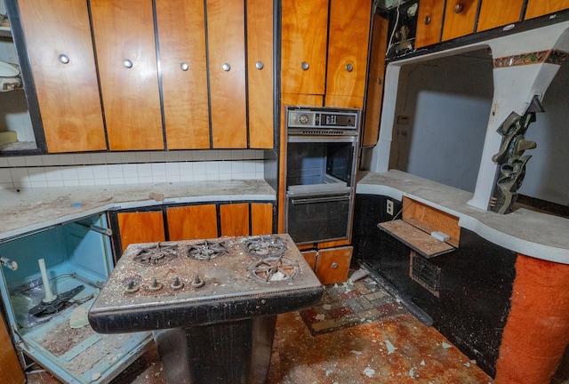 kitchen featuring black double oven and tasteful backsplash