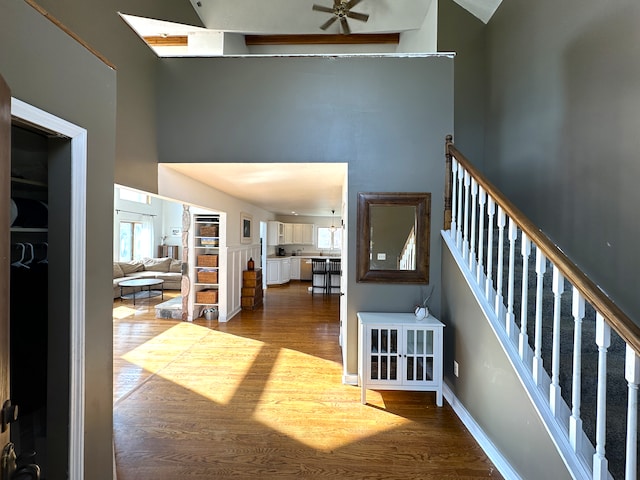 stairs featuring hardwood / wood-style floors, ceiling fan, and a towering ceiling