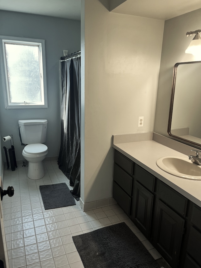 bathroom with tile patterned flooring, vanity, and toilet