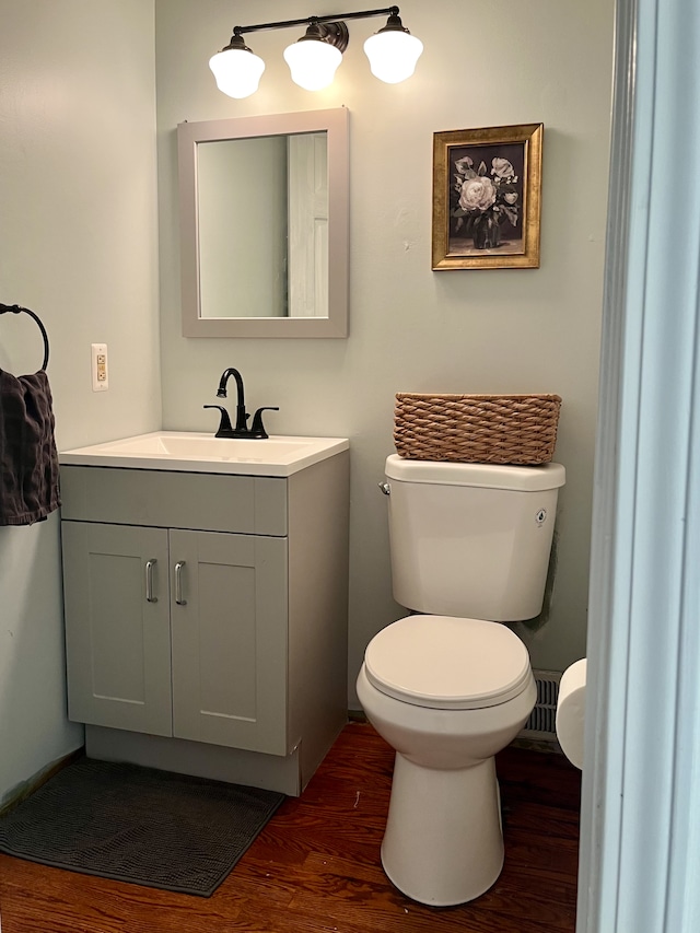 bathroom with hardwood / wood-style floors, vanity, and toilet