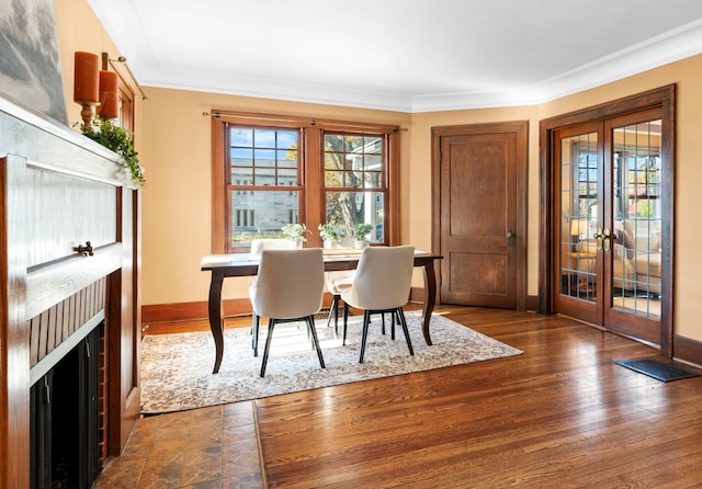 dining space featuring dark hardwood / wood-style flooring, ornamental molding, and french doors