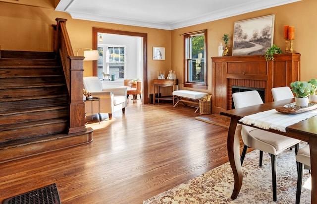 sitting room with a fireplace, a wealth of natural light, crown molding, and hardwood / wood-style flooring