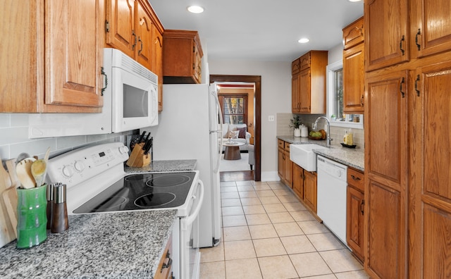 kitchen featuring white appliances, sink, decorative backsplash, light stone countertops, and light tile patterned flooring