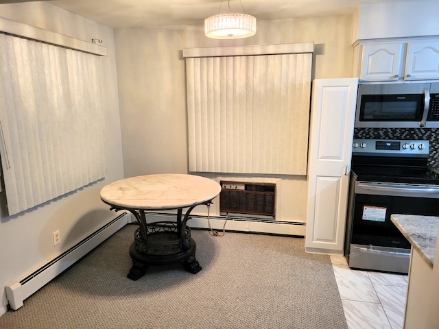 interior space featuring baseboard heating, a wall mounted AC, hanging light fixtures, and appliances with stainless steel finishes