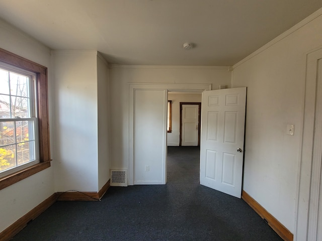 carpeted empty room featuring crown molding