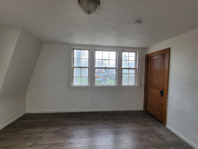 unfurnished room featuring dark hardwood / wood-style flooring and a textured ceiling