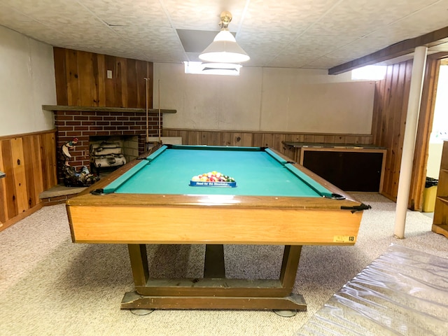 rec room with wooden walls, a fireplace, carpet, and pool table