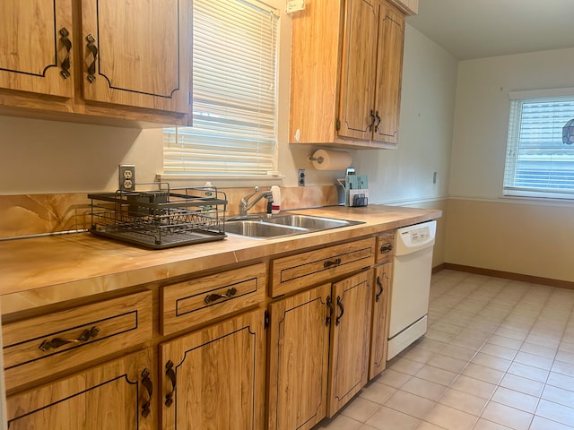 kitchen featuring dishwasher, light tile patterned flooring, and sink