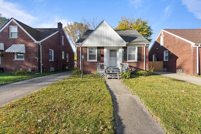 bungalow featuring a front yard and brick siding