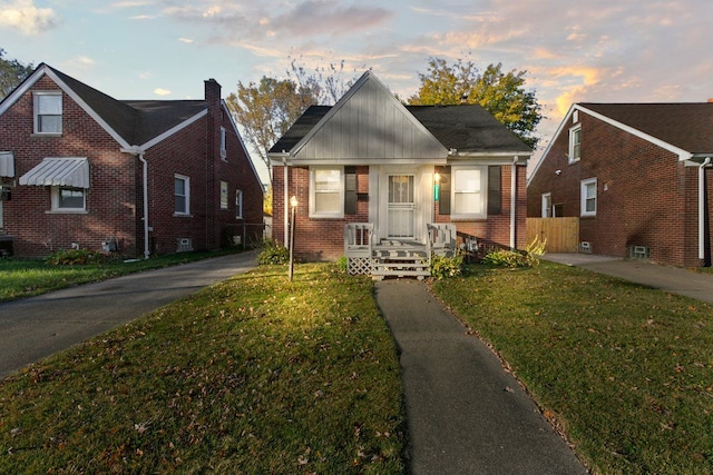 bungalow-style home with a front lawn and brick siding