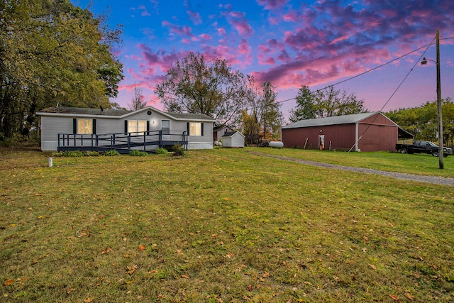 yard at dusk featuring an outbuilding and a deck