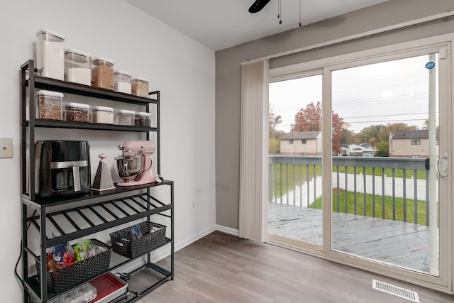 doorway to outside with light wood-type flooring and ceiling fan